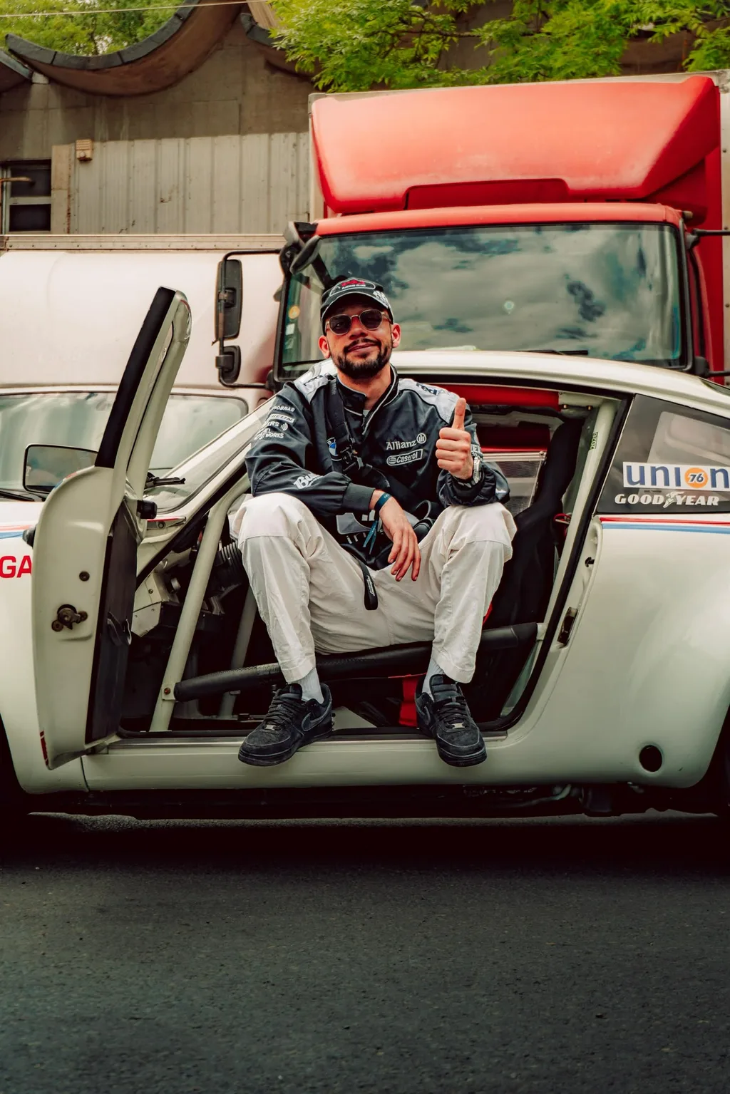 Christopher Lacavé assis dans l’ouverture de porte d’une voiture de course classique