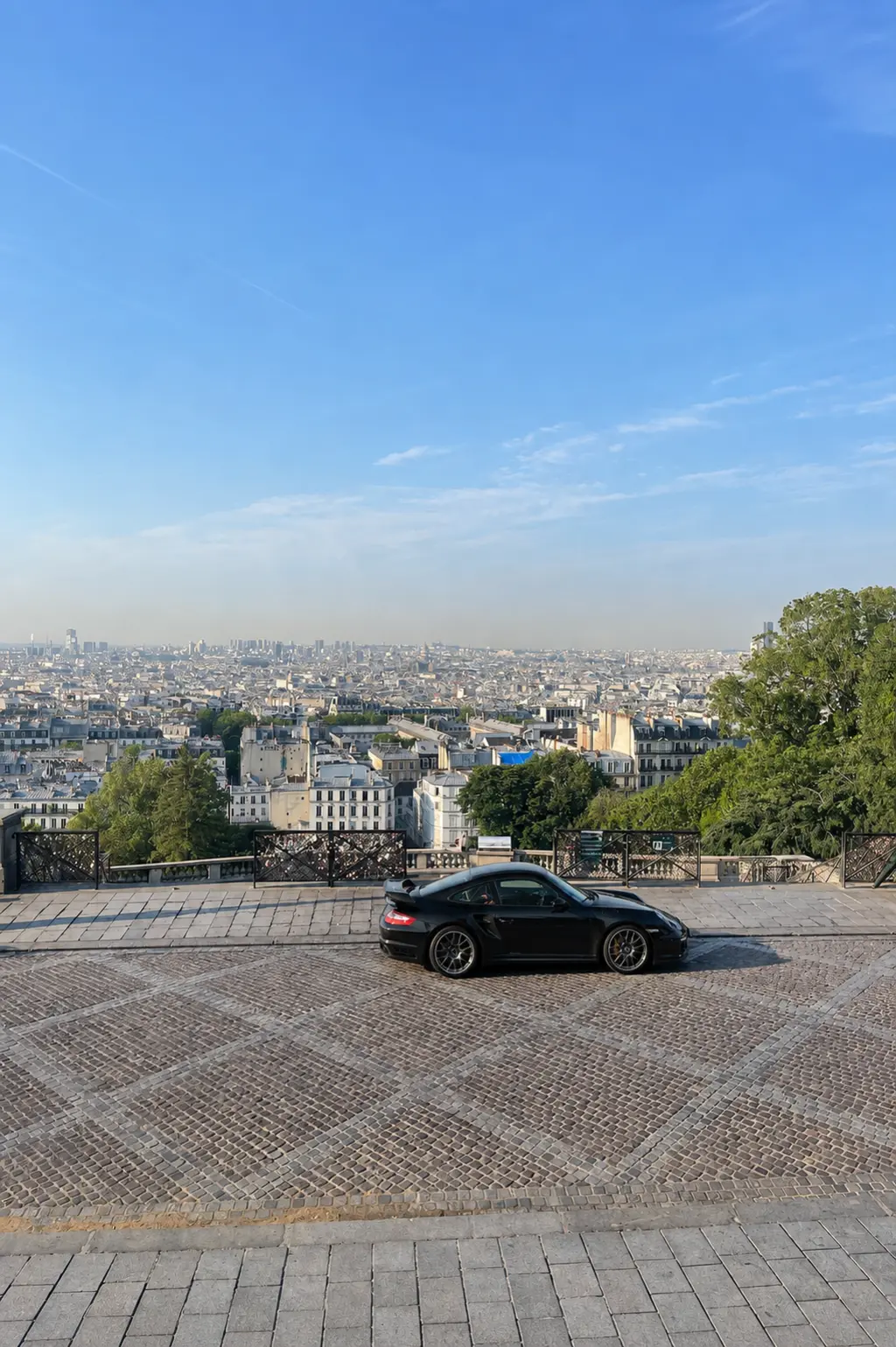 Black Porsche 997 GT2 with Paris in the background